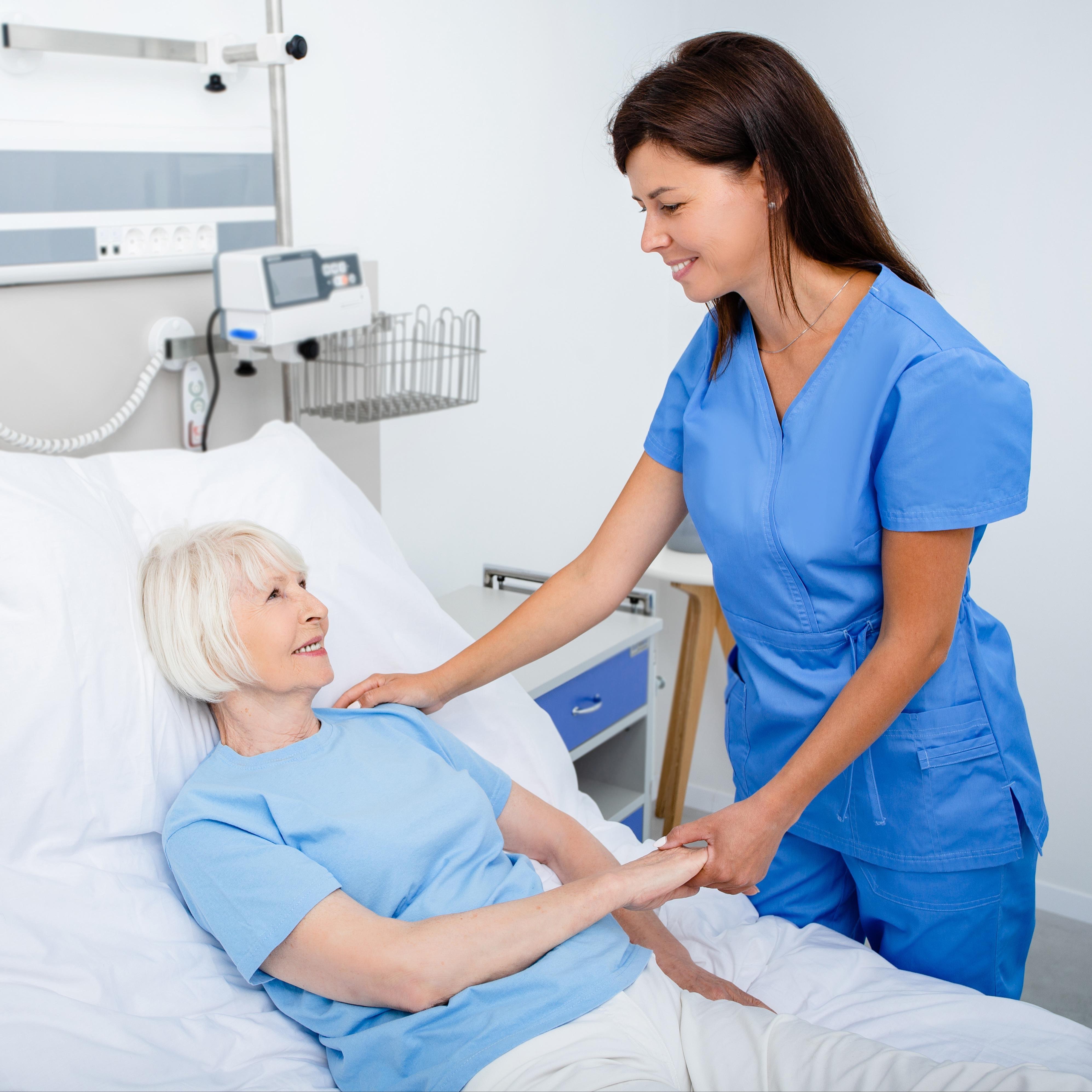 Nursing assistant holding a patient's hand