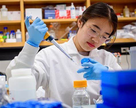 Undergraduate researcher pipetting in a lab